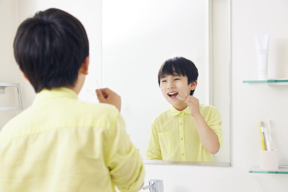 鏡の前でマウスピースをつけているお子様